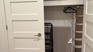 Ein Schrank mit weißer Tür, einem Metallgestell und Regalen.