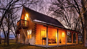 A log cabin with a balcony, a porch, and a fireplace. - Charming Cabin in Beautiful Park-Like Setting (Silt)