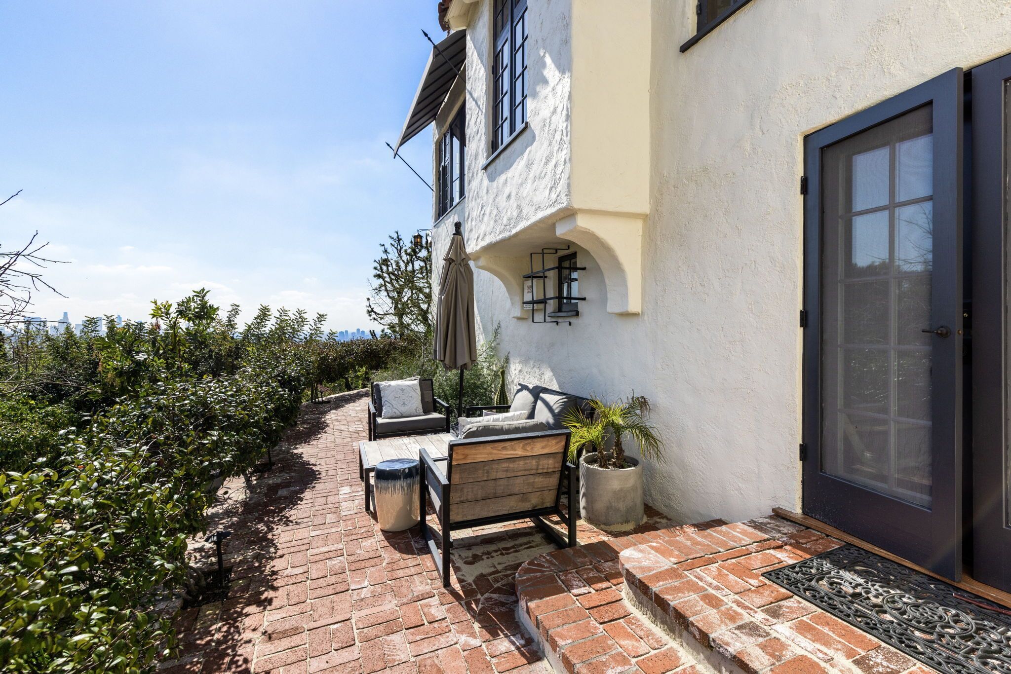 A patio with outdoor furniture, a potted plant, and a door with a glass panel.