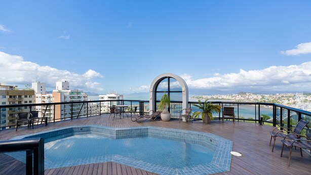 Une piscine sur le toit offrant une vue sur la ville et les montagnes.