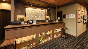 A reception desk with a decorative wall, a counter with display cases, and a carpeted floor.