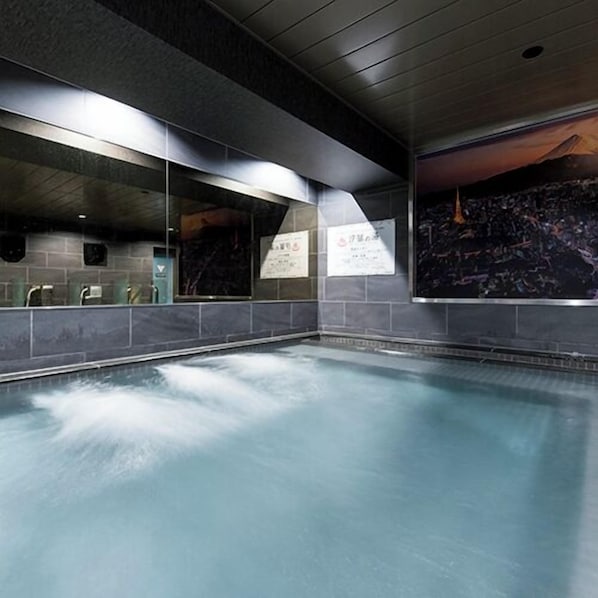 An indoor swimming pool with tiled walls and a mural of a cityscape. - Anshin oyado Tokyo Woman Ginza Shiodome (Tokyo)