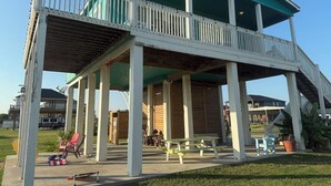 Un espacio al aire libre cubierto con una terraza de madera, bancos y una mesa de picnic.