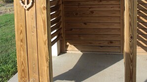 Una estructura de madera con una puerta y un adorno de ancla metálica.