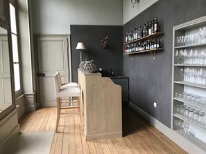 A room with a wooden floor, a bar area with a lamp, a guitar, and shelves with bottles and glasses. - Tremendous 8-bedroom castle in Isle-sur-Marne (Isle-sur-Marne)