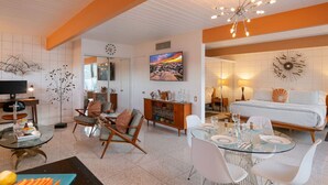 A modern living room with a glass dining table, white sofas, and a large painting on the wall. - Ocotillo mid-century lux pad with oversized patio (Palm Springs)