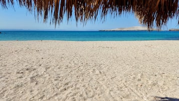 On the beach, white sand, sun loungers, beach towels