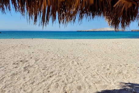 En la playa, arena blanca, sillas reclinables de playa, toallas de playa. Club Hotel Cantamar Beach & Marina