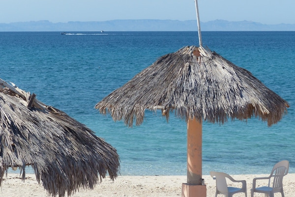 On the beach, white sand, sun-loungers, beach towels