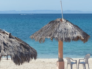On the beach, white sand, sun-loungers, beach towels