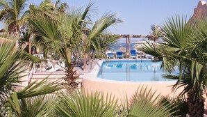 A pool surrounded by palm trees and lounge chairs. - Club Hotel Cantamar Beach & Marina (Pichilingue)
