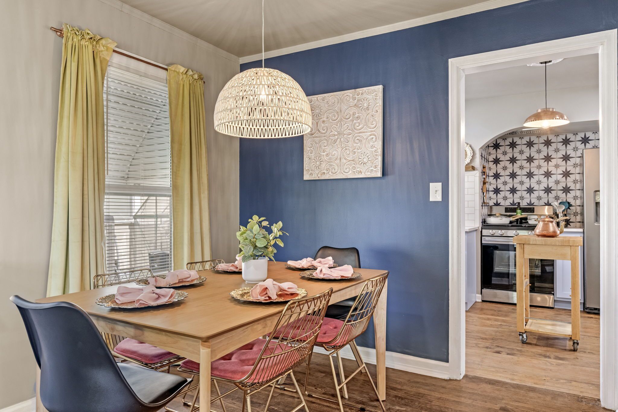 Un comedor con una mesa de madera dispuesta para cuatro personas, rodeado de sillas con asientos acolchados.