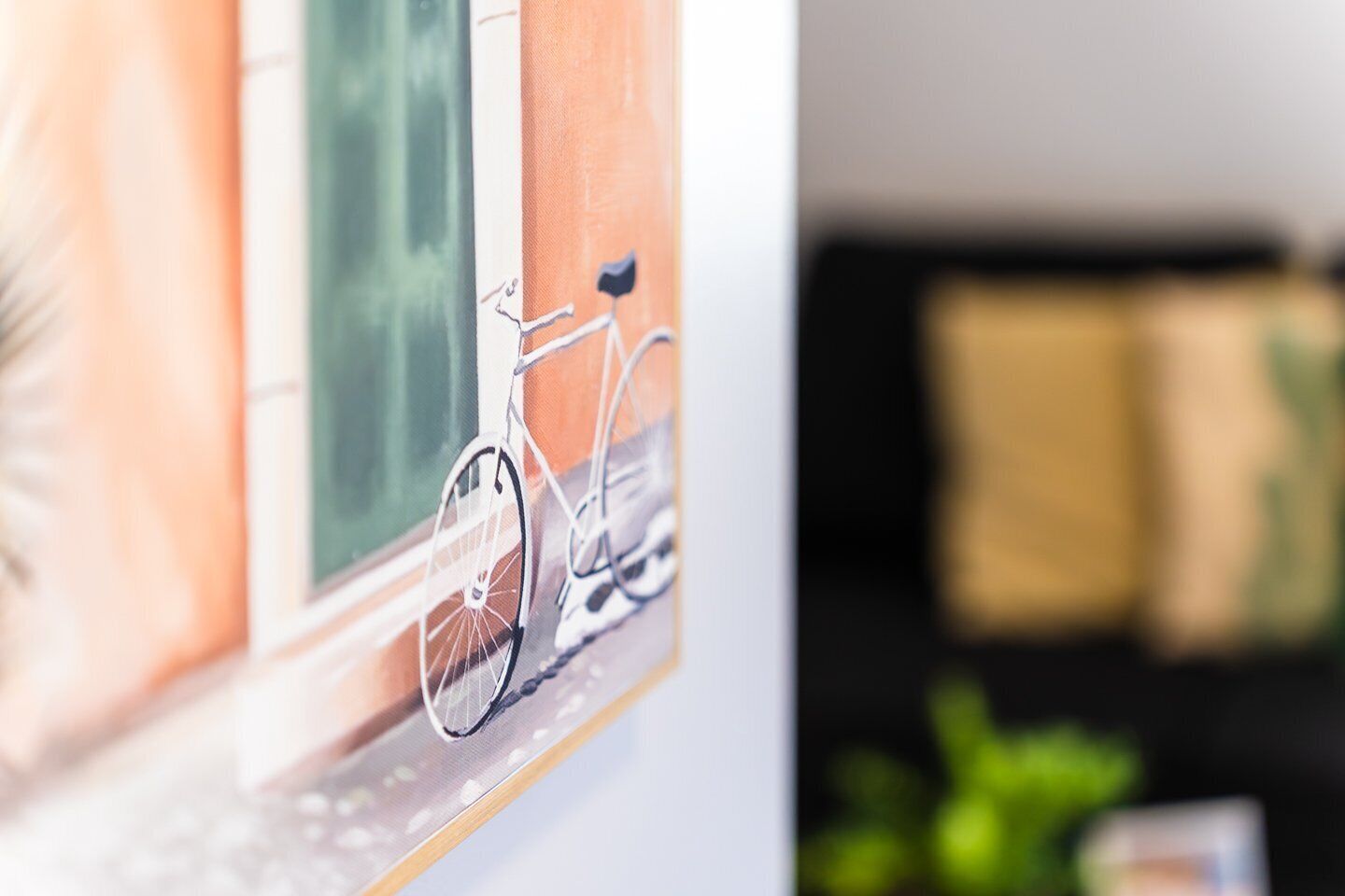 Une œuvre d’art encadrée représentant un vélo accroché au mur.