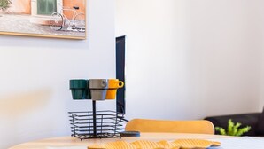 Ein Essbereich mit einem runden Tisch, einem Getränkehalter für Tassen, einem Stuhl und einem Bild an der Wand.
