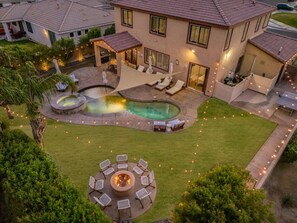 A residential backyard with a swimming pool, outdoor seating, and a fire pit. - Coachella Sol Haus: Spacious Desert Retreat (Indio)