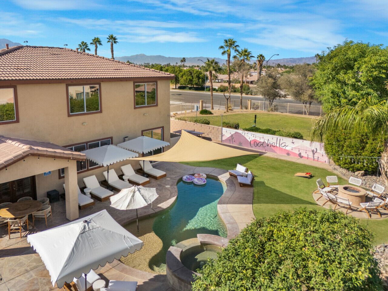 A pool area with lounge chairs, a hot tub, and a barbecue setup.