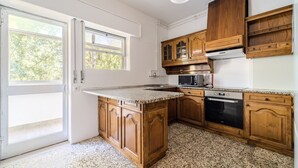 Eine Küche mit Holzausstattung, einer Granitarbeitsplatte, einer Mikrowelle und einem Backofen.