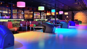 A bowling alley with multiple lanes, seating areas, and colorful lighting. - De Zoete Inval (Haarlemmerliede)