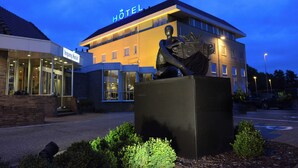 A hotel with a sign reading "Ingang Hotel" and a statue of a figure with a crown. - De Zoete Inval (Haarlemmerliede)