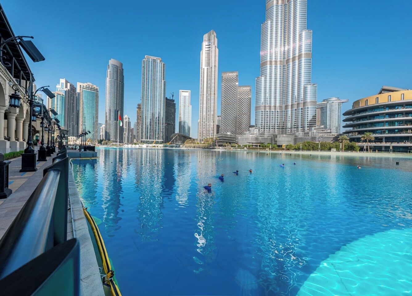 Un paisaje urbano con rascacielos modernos y una piscina grande y transparente.