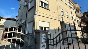 A multi-story building with a beige facade, numbered 72 and 74, and a metal gate in front. - United Residence (Mestre)