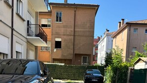 A gravel driveway leading to a residential building with a parked car. - United Residence (Mestre)