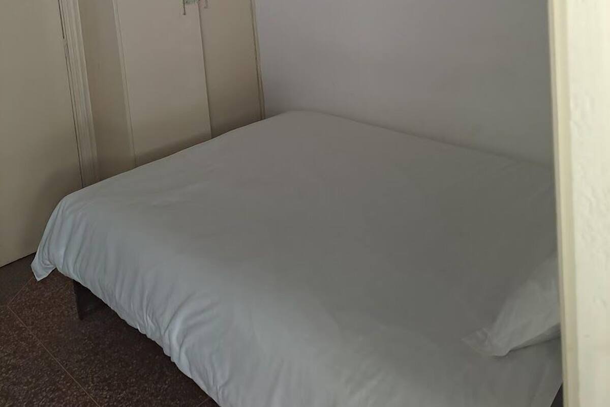 Un dormitorio con una cama individual, un armario y un techo con un adorno colgante.