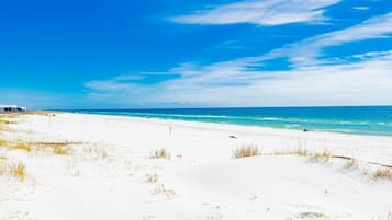 Una playa de arena blanca y cielo azul claro.