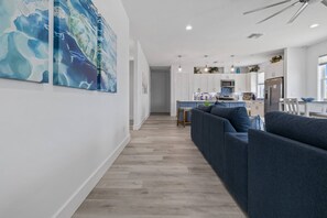 A modern kitchen with white cabinets, a blue countertop, and a stainless steel refrigerator.