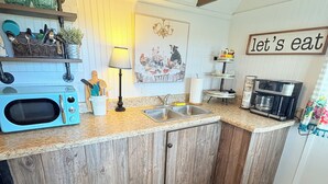 A kitchen with wooden cabinets, a microwave, a sink, and a coffee maker. - Cozy Cottage 1bed 1bath in Slocomb Al (Slocomb)