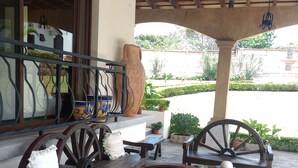 An outdoor seating area with wooden furniture and a stone planter. - La mansión  (San Isidro)