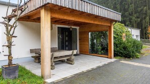 Une structure en bois comprenant un banc, une porte et une fenêtre.