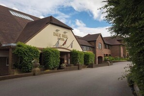 A hotel with a prominent sign, a paved driveway, and a well-maintained exterior. - Dale Hill Hotel (Ticehurst)