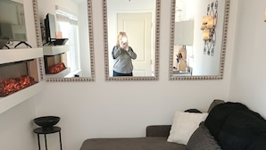 A modern living room with a grey sectional sofa, a black floor lamp, and a black side table. - Lovely studio in Sacramento near downtown. (Sacramento)