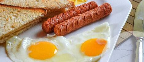 A breakfast plate with toast, sausages, and fried eggs.