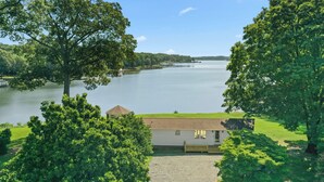 Une propriété au bord du lac comprenant une maison, un quai et une vue dégagée sur le lac.