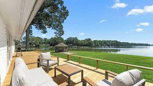 Une terrasse avec des sièges et une vue sur un lac.
