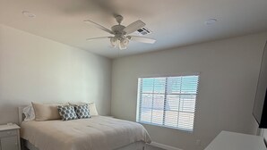 A bedroom with a bed, nightstand, dresser, ceiling fan, and window with blinds. - Newly Remodeled Chandler Gem — Stylish 3 Bed, 2 Bath Home Awaits! (Chandler)