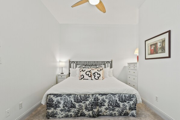 A bedroom with a bed, a nightstand, a dresser, a ceiling fan, and a framed picture on the wall. - Quiet Historic Corner Home Near Downtown (Savannah)