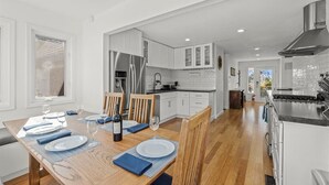A modern kitchen with white cabinets, a stainless steel refrigerator, and a black countertop. - Riverfront Escape in North Alexander Vly, 3BR/2BA, hot tub, bbq, bocce ball (Cloverdale)