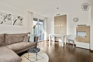 Deluxe-Apartment | Wohnbereich | 90-cm-Flachbildfernseher mit Kabelempfang