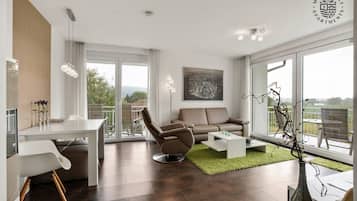 Deluxe Apartment | Living area | 90-cm flat-screen TV with cable channels