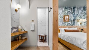 A bedroom with a wooden bed, a nightstand, a mirror, and a wall-mounted lamp. - Sommer House Inn-The Aloha Room (Newton County)