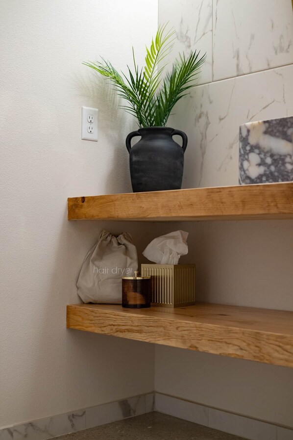 A corner with a potted plant, a hair dryer, and a tissue box on wooden shelves. - Sommer House Inn-The Aloha Room (Newton County)