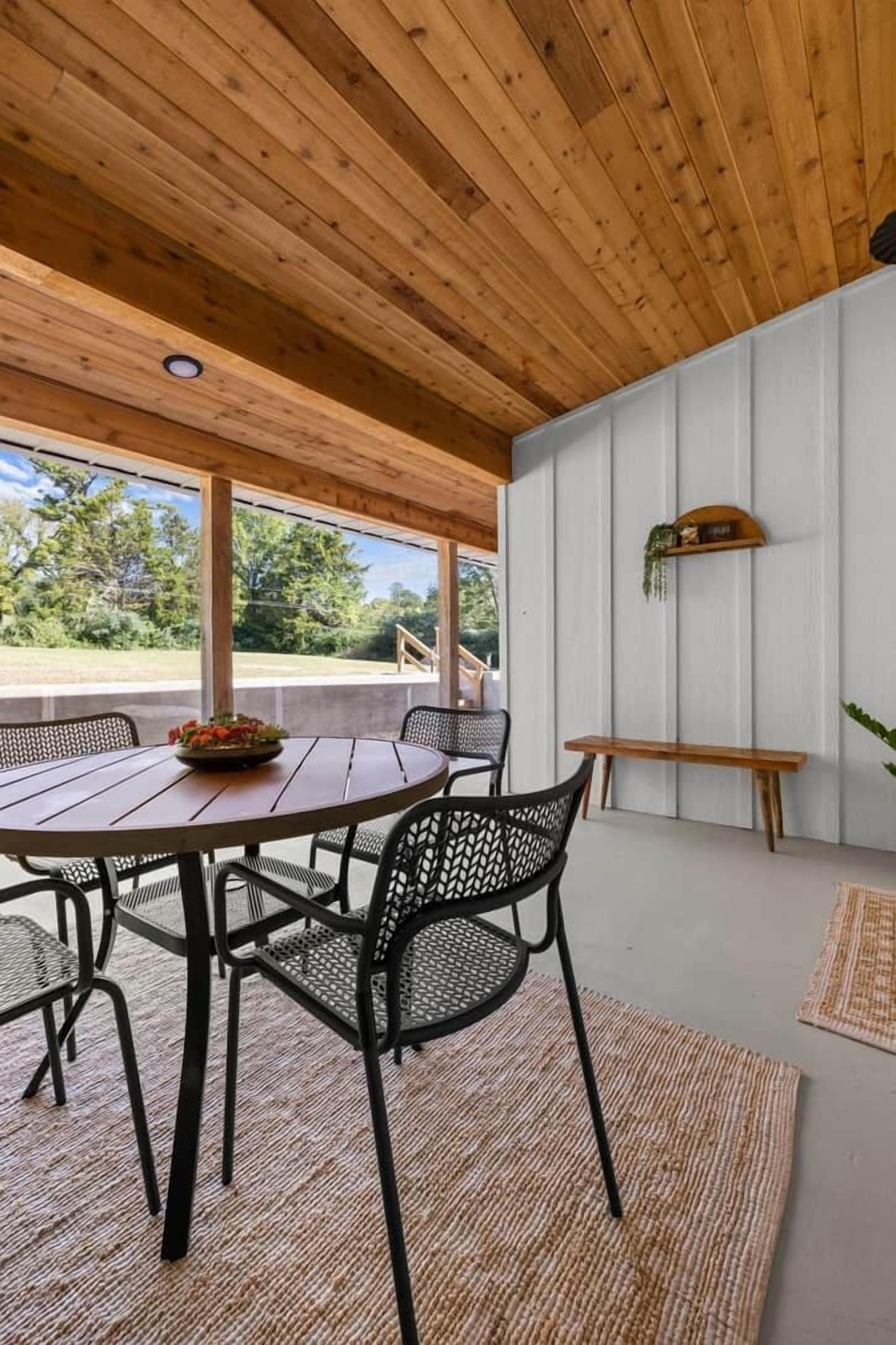 Techo de madera, una mesa de comedor con sillas y un banco.