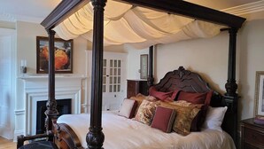 A four-poster bed with a canopy, a fireplace, and a painting on the wall. - Iconic Luxurious Downtown Building History Galore (Halifax)