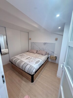 A bedroom with a bed, a wardrobe, a nightstand, and a mirror. - Living in the Heart of Cannes (Cannes)