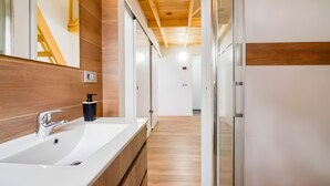 A modern bathroom with a large mirror, a white sink, wooden paneling, and a wooden ceiling. - Vacation Villa 'Adrián' with Mountain View, Wi-Fi and Air Conditioning (Las Palmas)