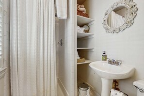 Une salle de bain avec une douche, un lavabo et un miroir.