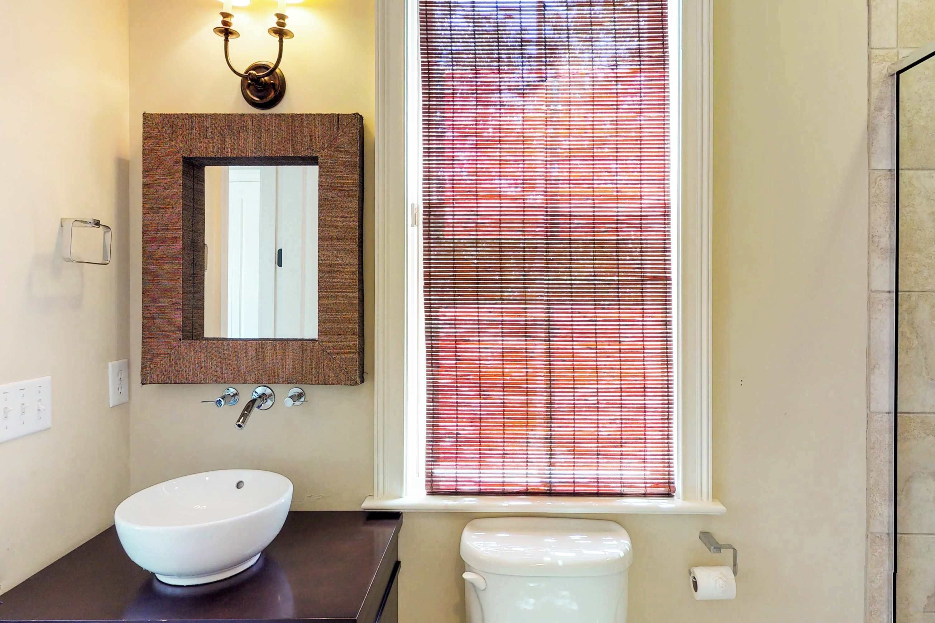 Een badkamer met een witte wastafel, een spiegel en een toilet.